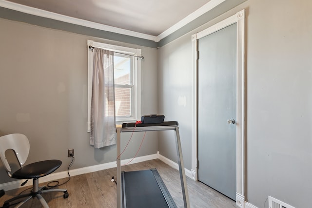 workout area featuring visible vents, light wood-style floors, and baseboards