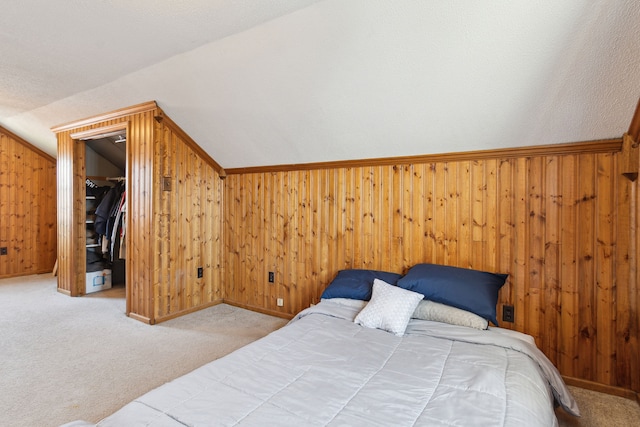 bedroom featuring wood walls, lofted ceiling, and carpet floors