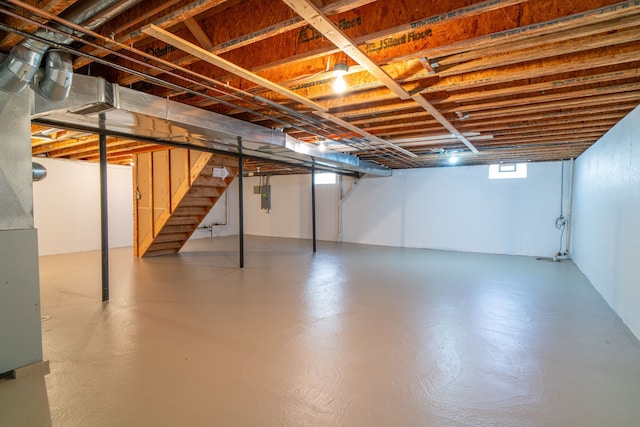 basement featuring stairs and electric panel