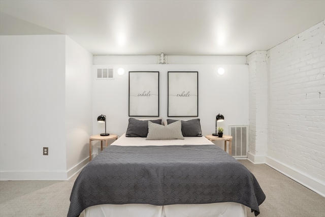 carpeted bedroom featuring visible vents, brick wall, and baseboards