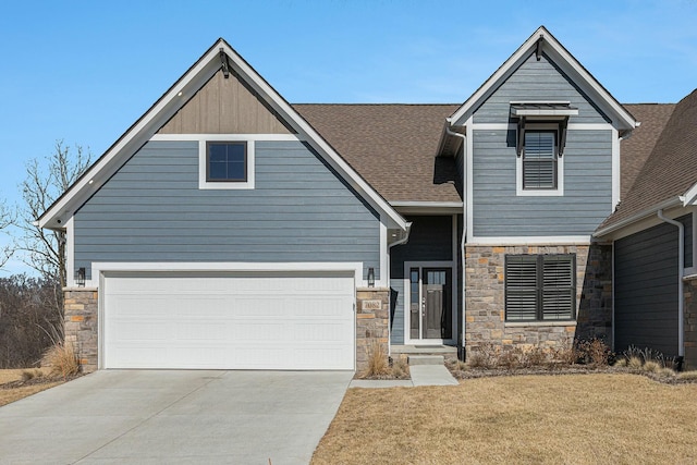 view of front facade featuring stone siding, driveway, a front lawn, and roof with shingles