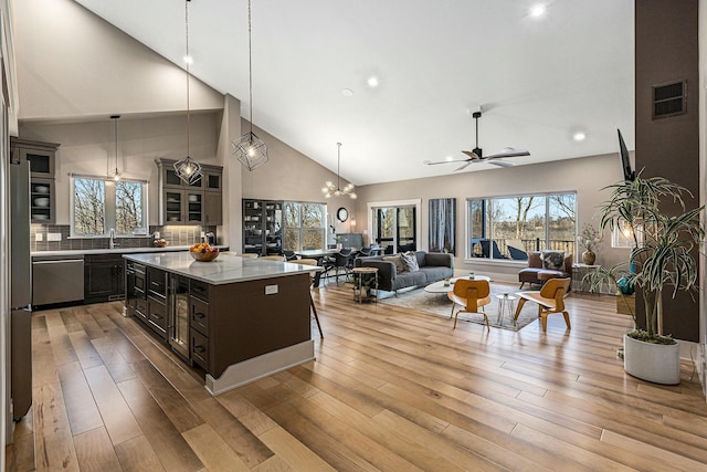 kitchen featuring light wood-style floors, a kitchen island, stainless steel dishwasher, and open floor plan