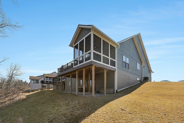 back of property featuring a yard, central AC unit, a sunroom, and a wooden deck