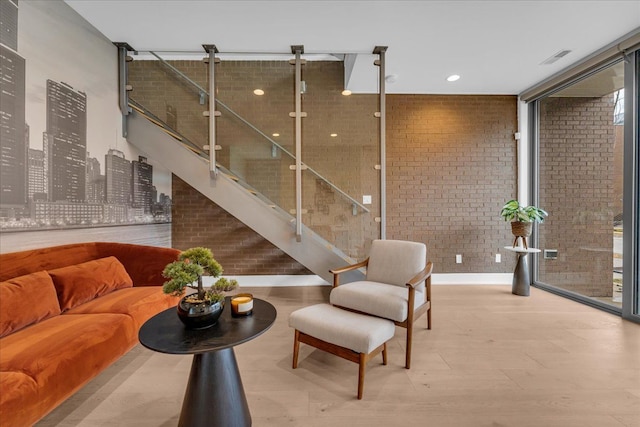 living area featuring wood finished floors and brick wall