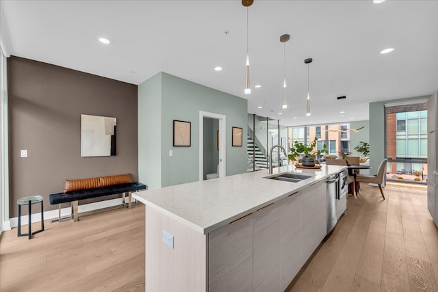 kitchen featuring light wood finished floors, a sink, a large island, modern cabinets, and open floor plan