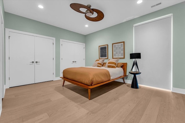 bedroom featuring recessed lighting, visible vents, multiple closets, and light wood-type flooring