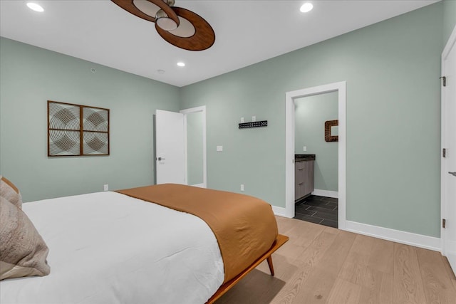 bedroom featuring recessed lighting, ensuite bath, baseboards, and wood finished floors