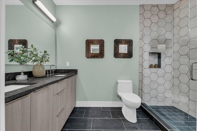 full bathroom with baseboards, toilet, a stall shower, tile patterned floors, and a sink