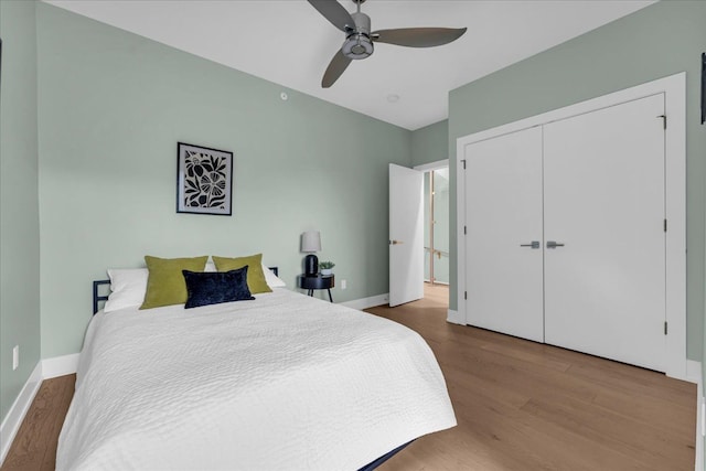 bedroom with a ceiling fan, wood finished floors, and baseboards