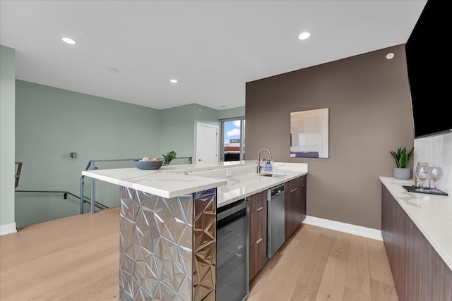 kitchen featuring wine cooler, dishwasher, a peninsula, light wood-style floors, and a sink