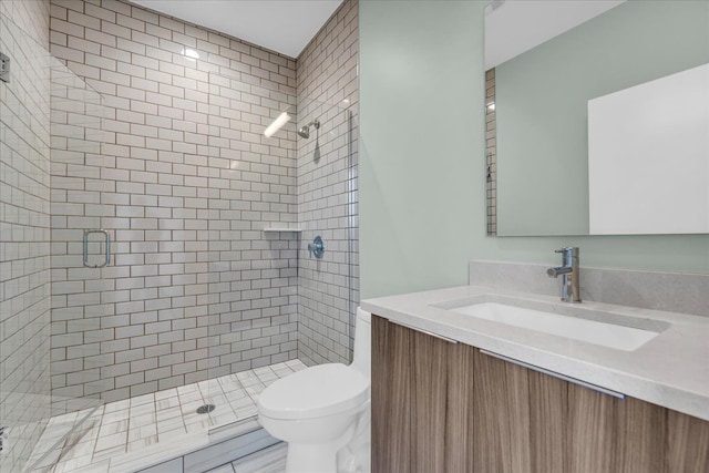 full bathroom featuring vanity, a shower stall, and toilet