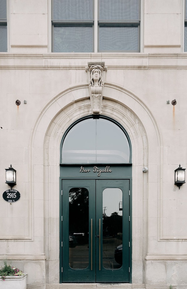 view of exterior entry featuring french doors and stone siding