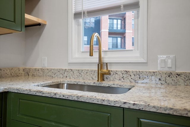 details with green cabinetry, a sink, and open shelves