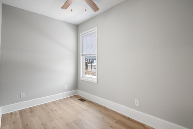 spare room with light wood-style floors, baseboards, ceiling fan, and visible vents