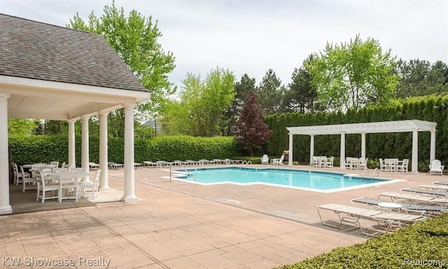 pool with a patio area and a pergola