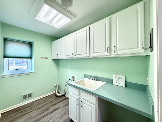 laundry room with visible vents, baseboards, hookup for a washing machine, cabinet space, and a sink