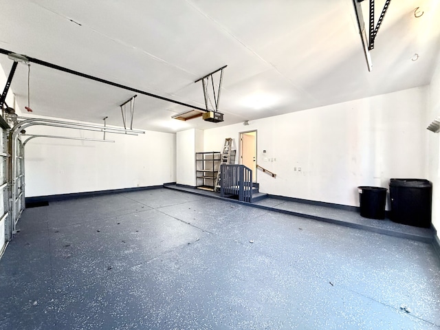 garage featuring a garage door opener and baseboards