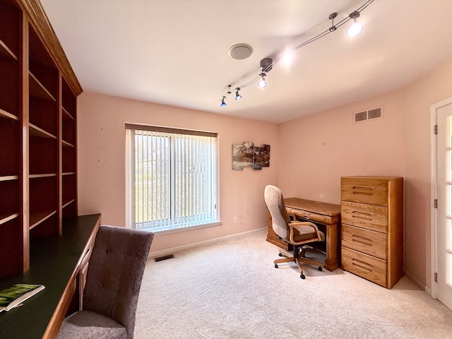 office space featuring visible vents, light colored carpet, track lighting, and baseboards