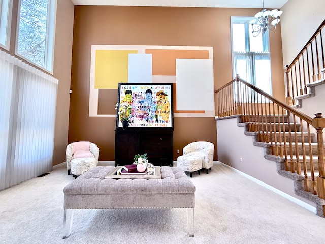 living room with baseboards, a high ceiling, stairs, carpet flooring, and a notable chandelier