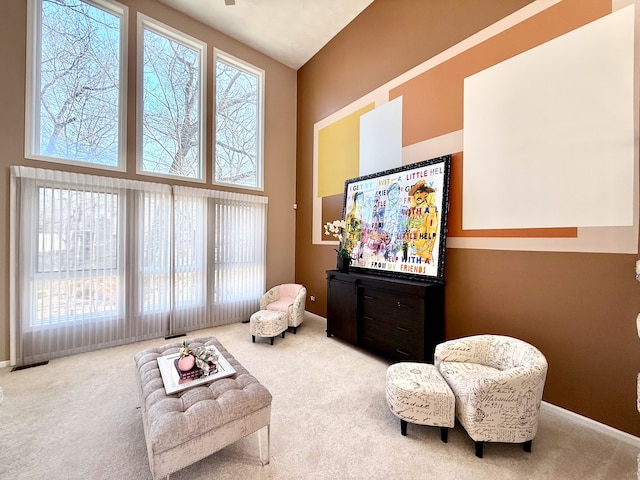 sitting room featuring a high ceiling, carpet, and baseboards