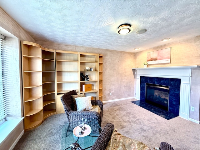 sitting room with baseboards, carpet floors, a textured ceiling, and a fireplace