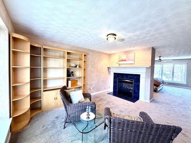 living area featuring baseboards, carpet floors, a textured ceiling, and a high end fireplace