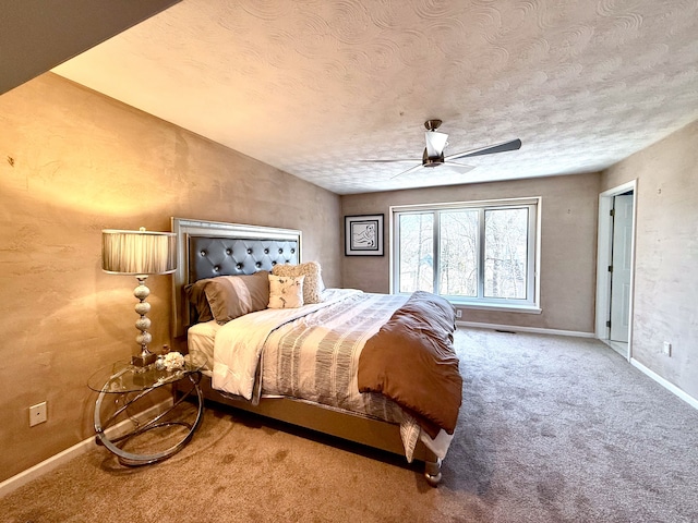 bedroom featuring baseboards, a textured ceiling, carpet floors, and a ceiling fan