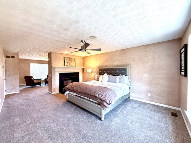 unfurnished bedroom featuring visible vents, baseboards, carpet floors, a fireplace, and a textured ceiling