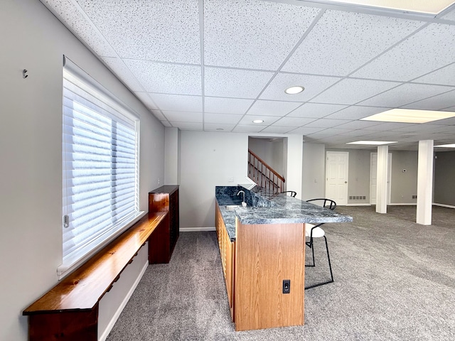 carpeted office with baseboards and a drop ceiling