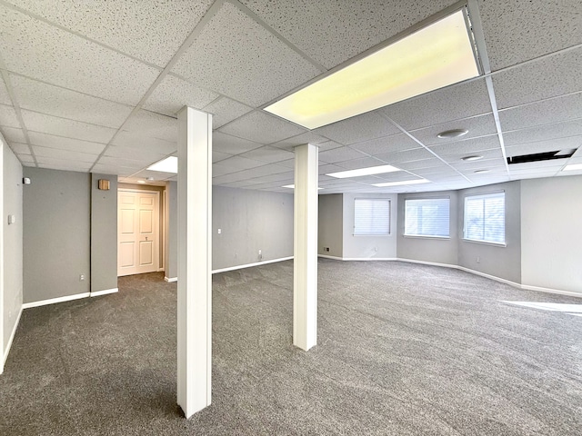 basement featuring carpet, baseboards, and a drop ceiling