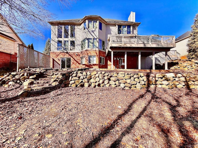 exterior space featuring a deck, brick siding, and a chimney