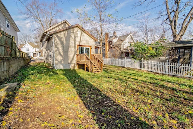 rear view of property featuring fence private yard and a lawn