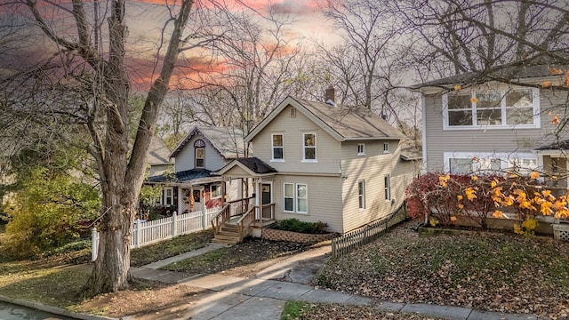 view of front of property with a chimney and fence