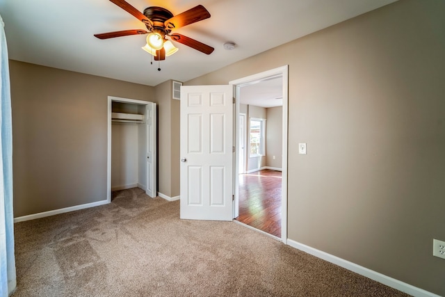 unfurnished bedroom with baseboards, carpet floors, a closet, and visible vents