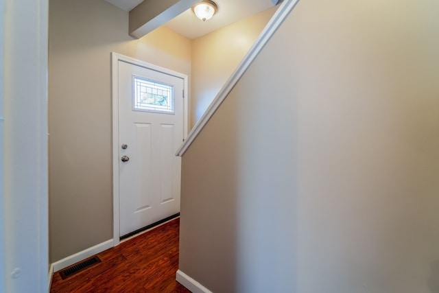 foyer entrance featuring visible vents, baseboards, and wood finished floors