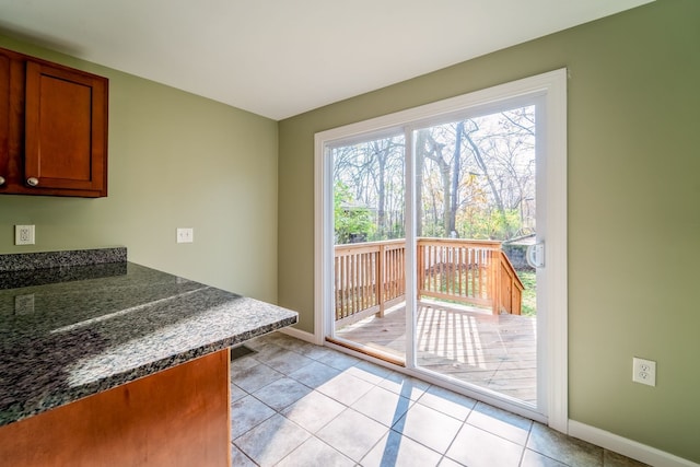 doorway to outside with light tile patterned floors and baseboards