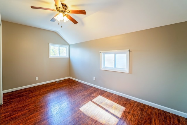 unfurnished room featuring a ceiling fan, wood finished floors, baseboards, visible vents, and lofted ceiling