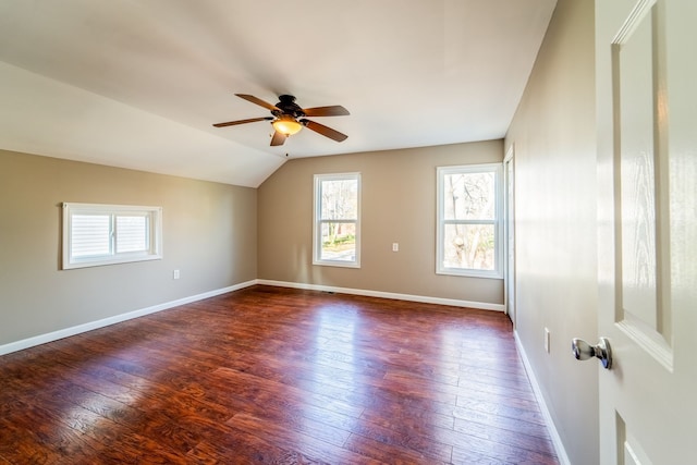 unfurnished room featuring baseboards, dark wood finished floors, a ceiling fan, and vaulted ceiling