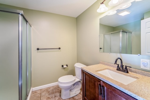 bathroom with a shower stall, baseboards, toilet, tile patterned floors, and vanity