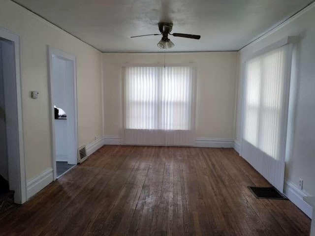 unfurnished room with hardwood / wood-style flooring, baseboards, visible vents, and ceiling fan