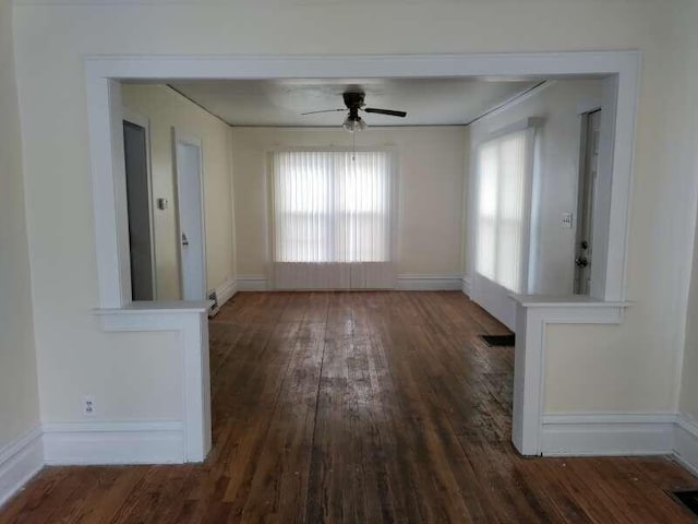 interior space with baseboards, wood-type flooring, and ceiling fan
