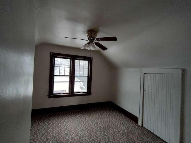additional living space featuring baseboards, lofted ceiling, carpet, and ceiling fan
