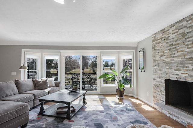 living room featuring baseboards, wood finished floors, and a fireplace