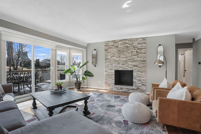 living room featuring baseboards, wood finished floors, and a fireplace