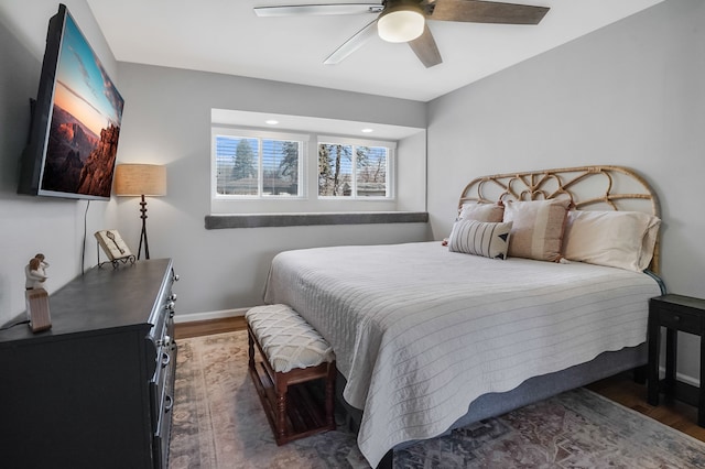 bedroom featuring a ceiling fan, baseboards, and wood finished floors