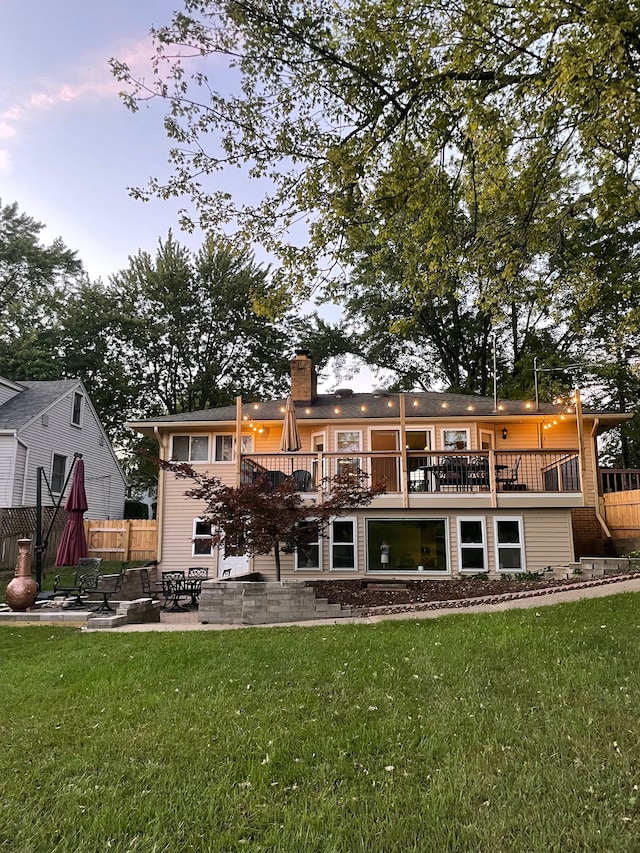 rear view of property featuring a yard, a chimney, a patio, and fence