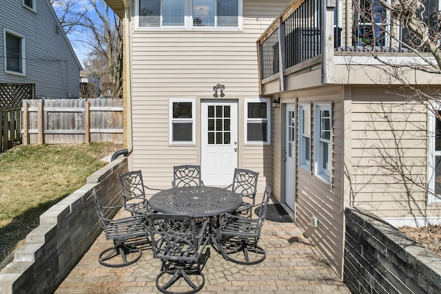 view of patio / terrace featuring a balcony, outdoor dining area, and fence