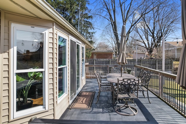 wooden terrace featuring outdoor dining area and fence