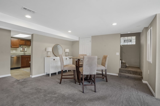 dining space featuring visible vents, light colored carpet, stairs, and baseboards