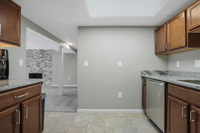 kitchen featuring a drop ceiling, baseboards, light stone countertops, and dishwasher